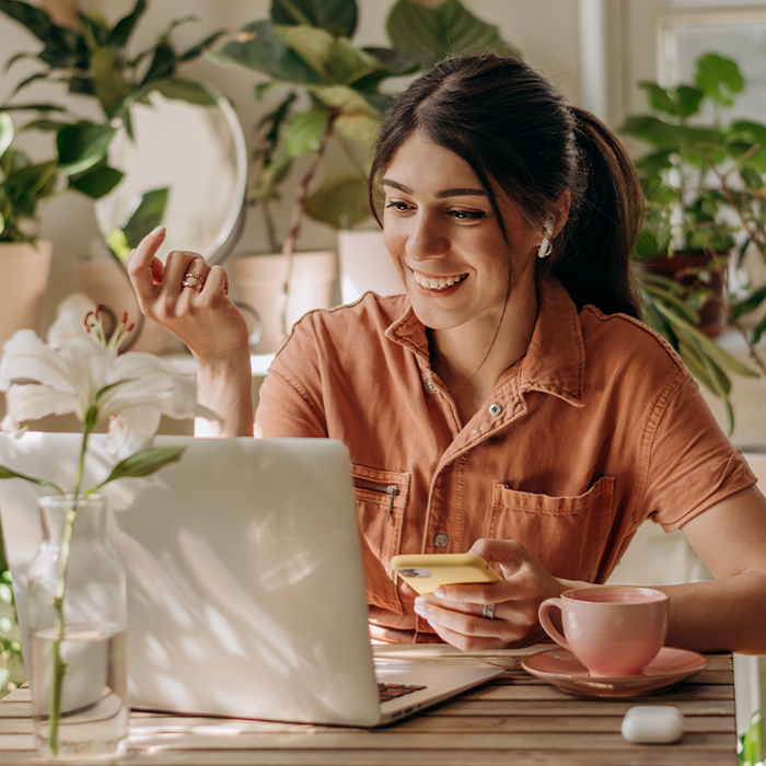 woman sitting in front of laptop surrounded by house plants