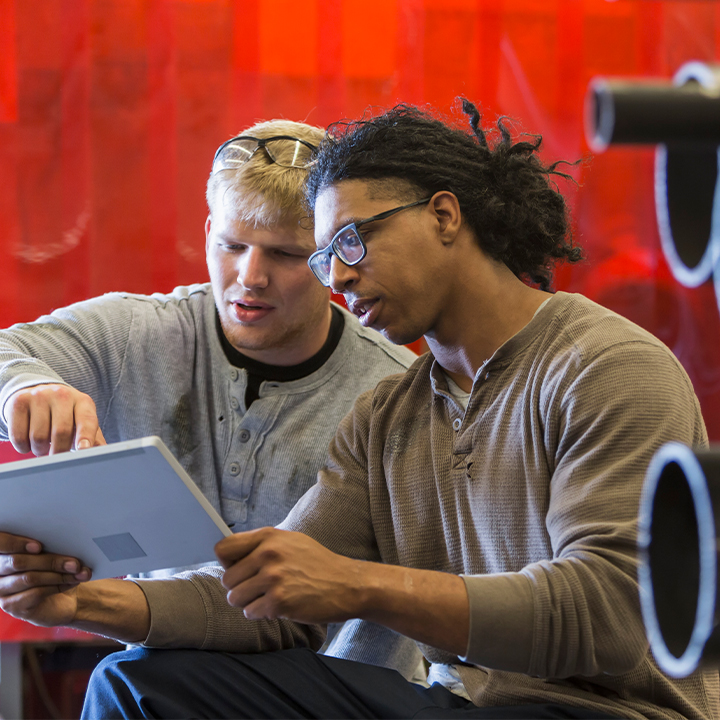 two people looking at a tablet discussing 