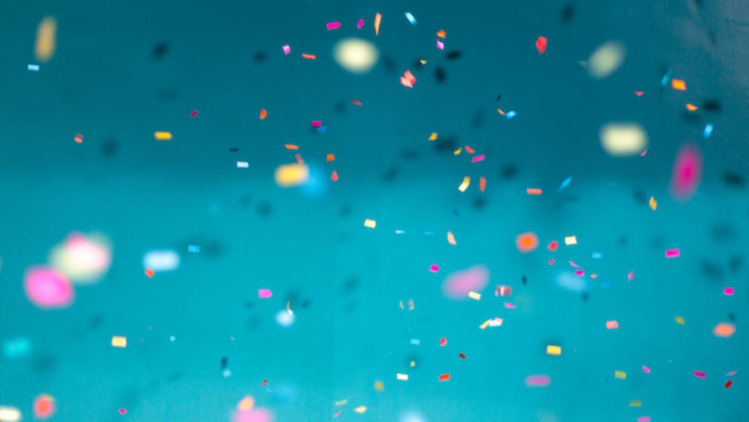 Blue background with various colored confetti pieces 