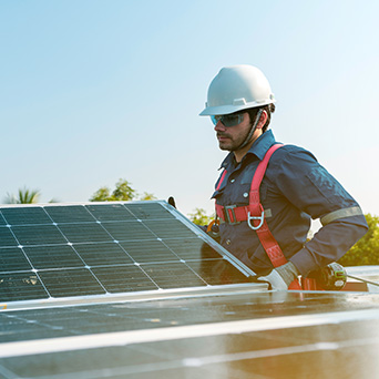 construction worker in a white hard hat placing solar panels