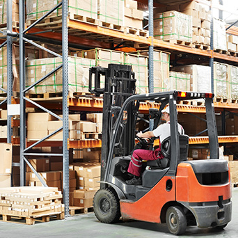 warehouse worker operating a forklift to pull a pallet out