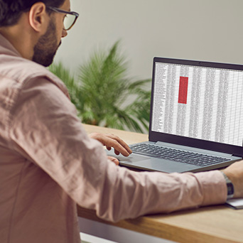 someone sitting at a desk working on a laptop