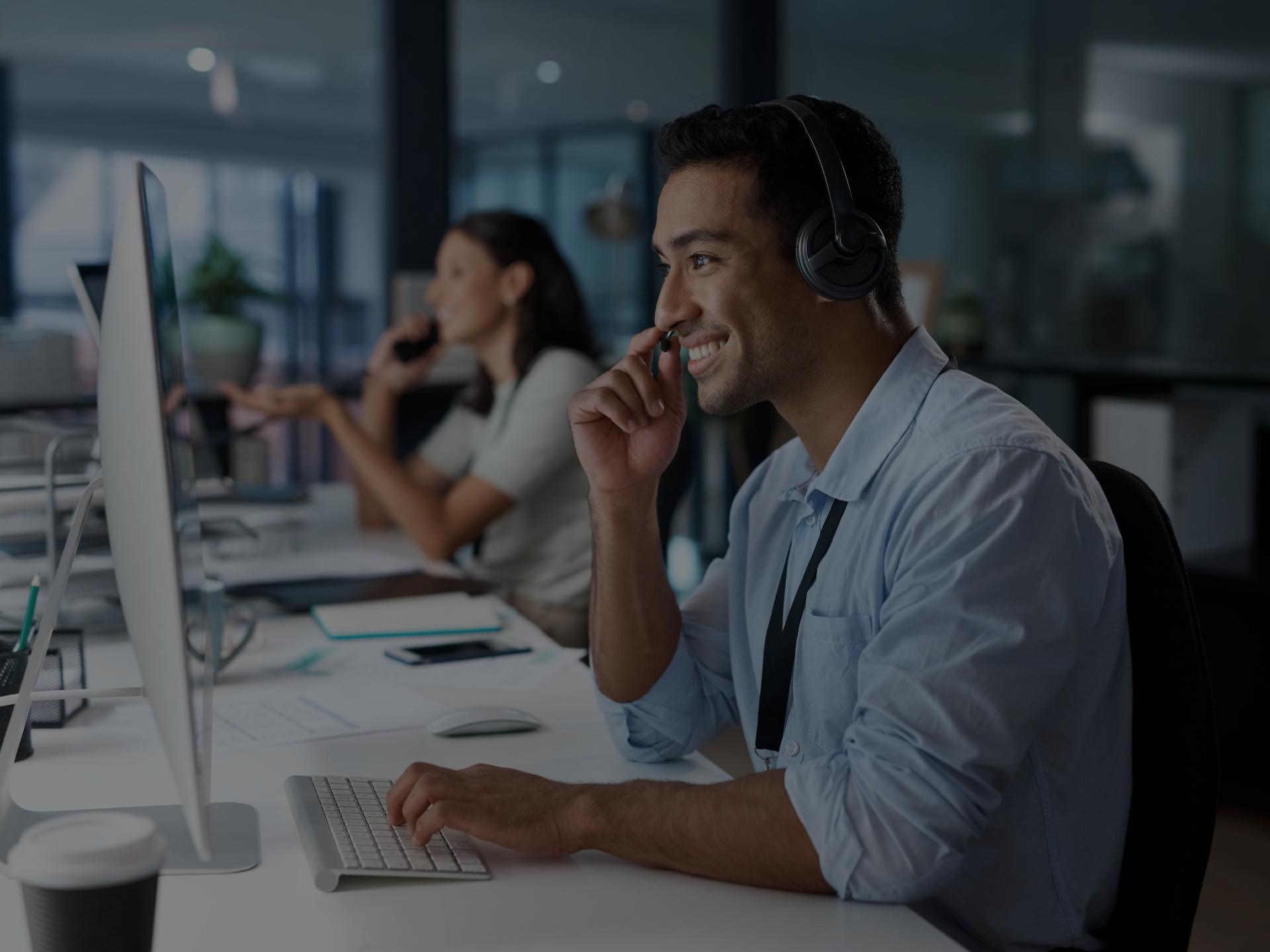 An office worker with headphones on, focusing on his work.