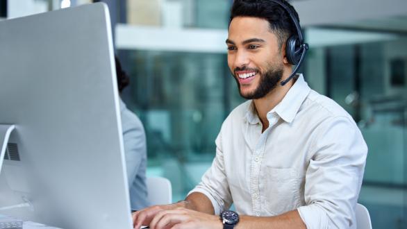 An office worker with headphones on, focusing on his work.